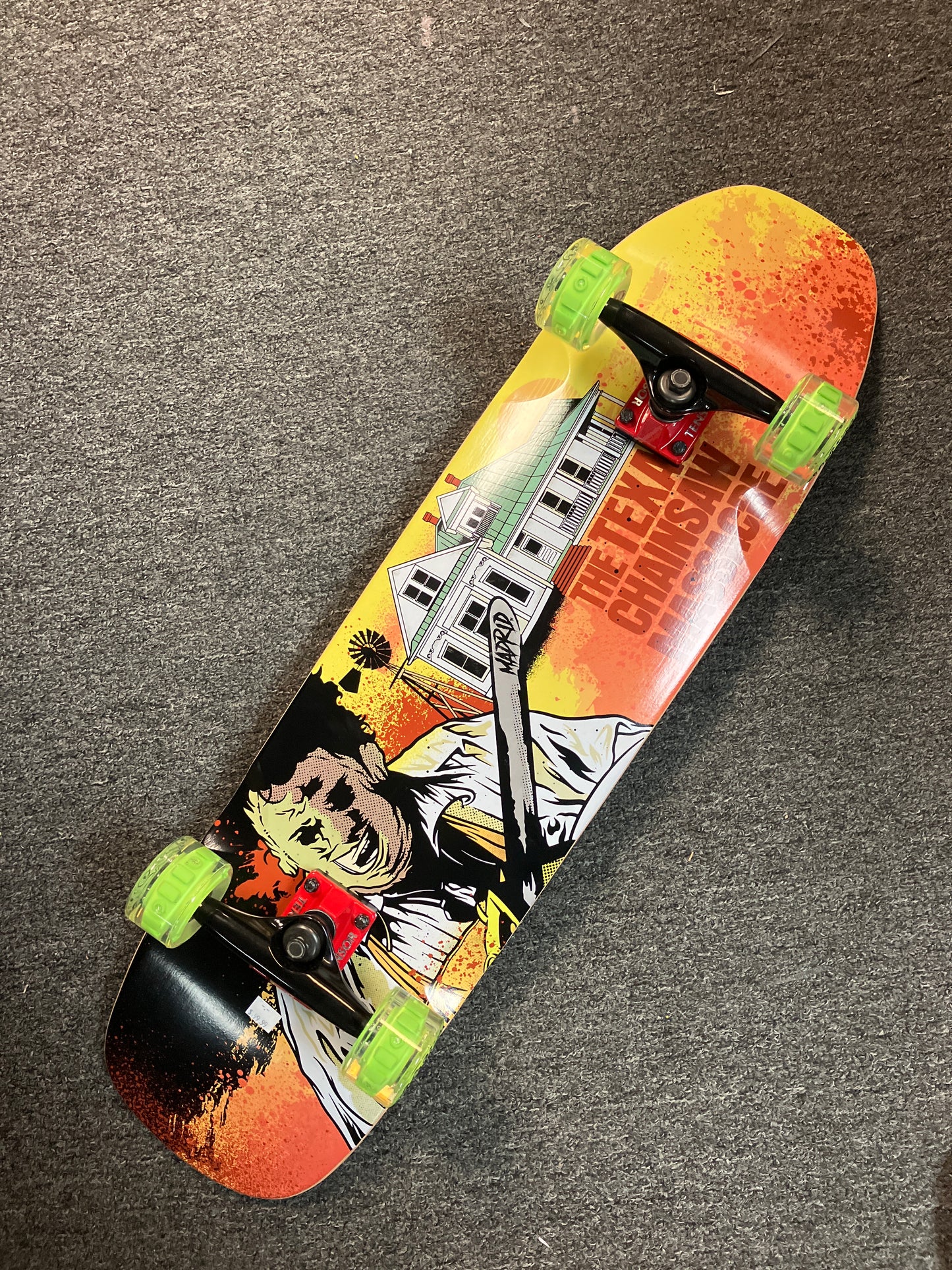 Madrid Complete Skateboard Texas Chainsaw Massacre 9”x33.5” pool shape with Tensor Trucks & green Slimeball light up wheels.